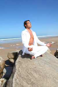 做冥想练习在海滩上的人