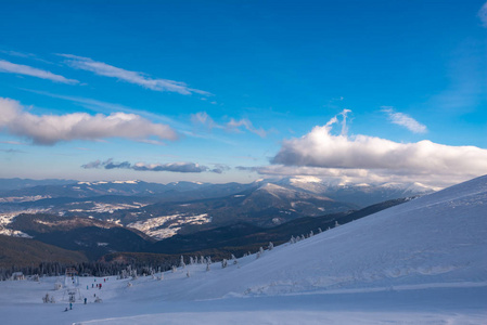 山的全景在冬天与滑雪推力在前景山脉覆盖了雪, 舒展到天际在深蓝色天空之下。广角