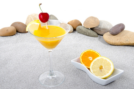 橙汁调配的鸡尾酒，背景为砂 卵石的石头