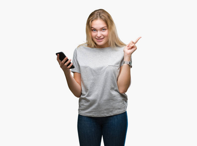 年轻的高加索妇女发送消息使用智能手机在孤立的背景非常高兴用手和手指指向一边