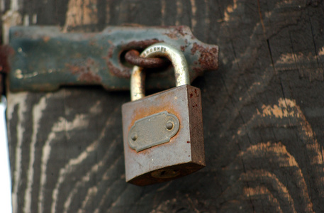 被遗弃的旧木门旧木门用生锈的挂锁锁照片