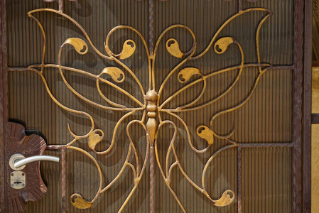 在墙壁上的门把手铸铁蝴蝶图案棕色金属纹理