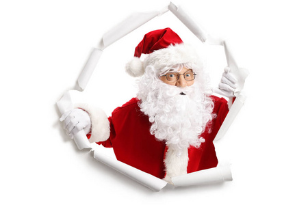 从白色背景查出的纸洞中出现的圣诞老人