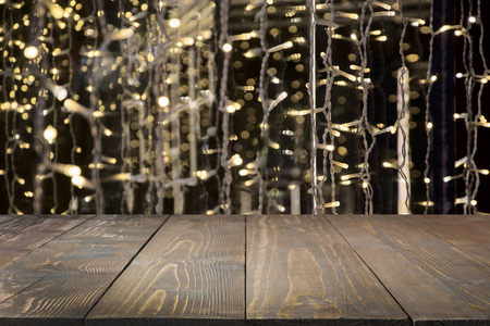 模糊的黄金花环作为背景和作为前景的木桌。圣诞节的抽象。显示的图像或蒙太奇你圣诞产品