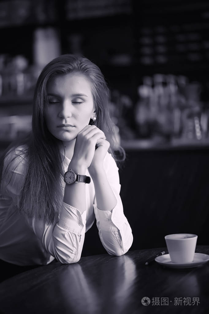 咖啡馆里的一个女孩正在喝咖啡一个女人正在吃早饭