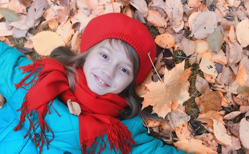 女孩在秋天城市公园在叶子秋天。年轻美丽的母亲