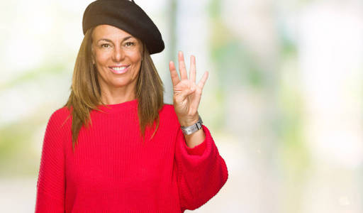 中年成年女性穿着时尚贝雷帽在孤立的背景下, 一边微笑着自信和快乐, 一边用手指指着四号