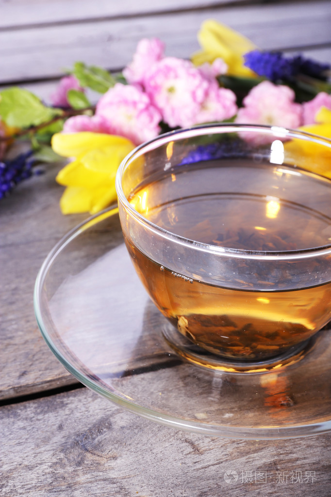 杯花草茶与花在木桌子上特写