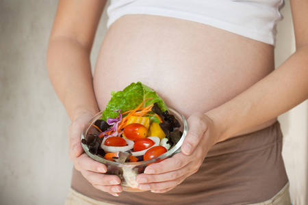 孕妇的肚子和蔬菜沙拉