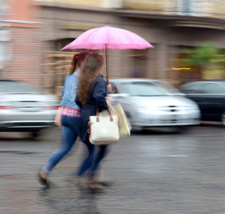 妇女走在街上，在一个下雨天