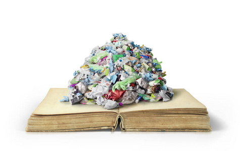 在白色背景下打开的书本上的垃圾堆照片