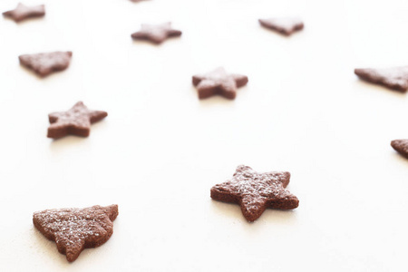 姜饼饼干的形状的星星和冷杉树与冰糖在白色的背景。简约风格的圣诞节模式