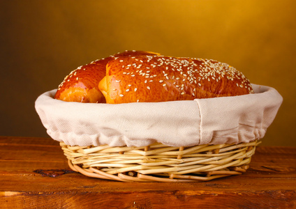 在棕色背景上的木桌上的篮子里烤的面包
