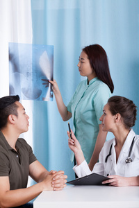 女医生分析她亚洲的病人的 x 光照片