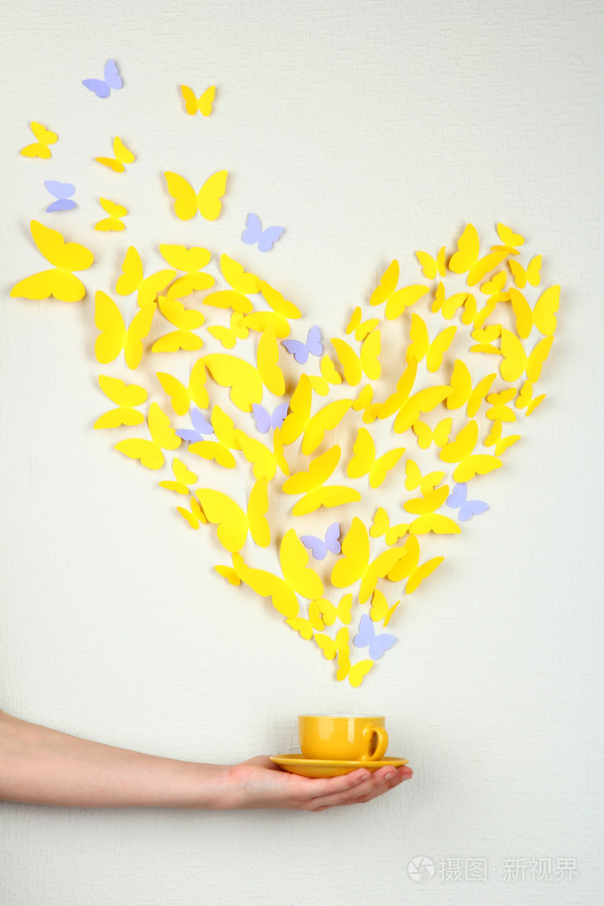 在窗体的心飞出杯中黄色的纸蝴蝶