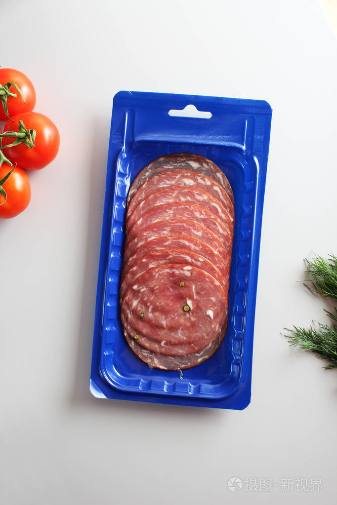 蓝色真空包装香肠在浅色背景下切割