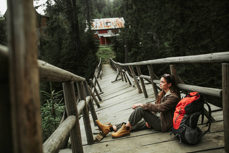 带背包的年轻女士在木桥上休息图片