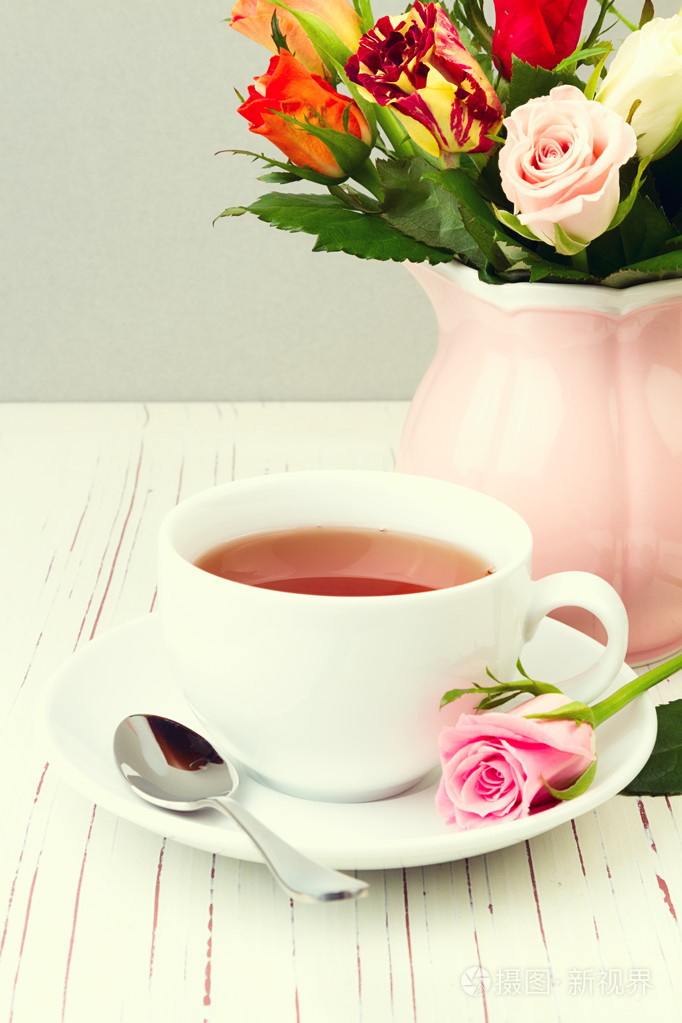 喝杯茶与月季花的木桌上