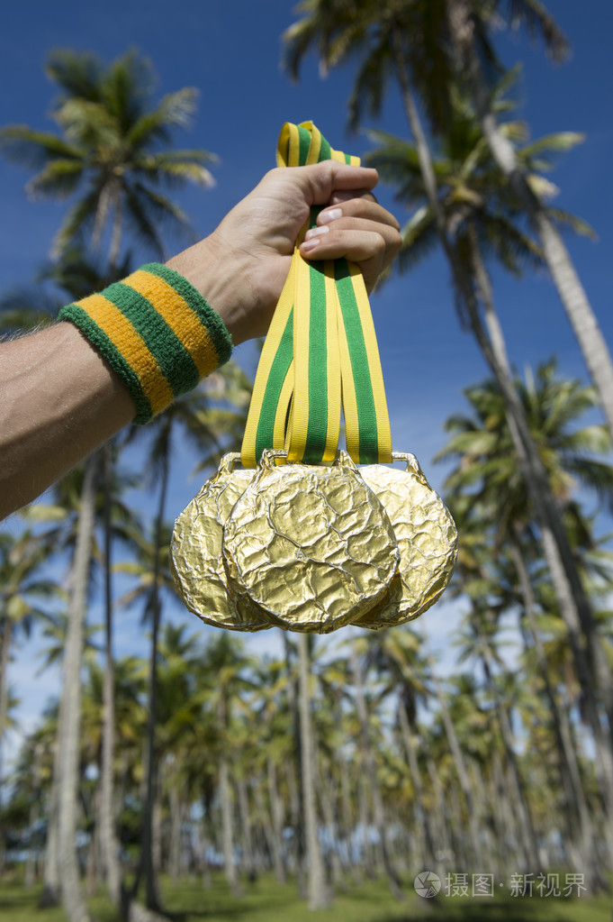 手中拿着金牌棕榈树的运动员