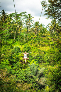 在热带巴厘岛的丛林雨林里荡秋千的年轻旅游女子
