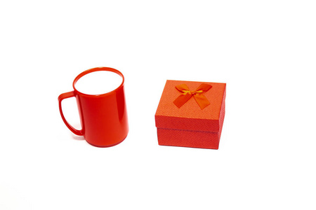 红色礼品盒与弓和空杯查出的白色背景