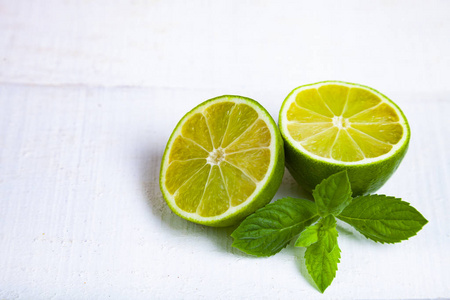 石灰和薄荷在白色木桌上照片
