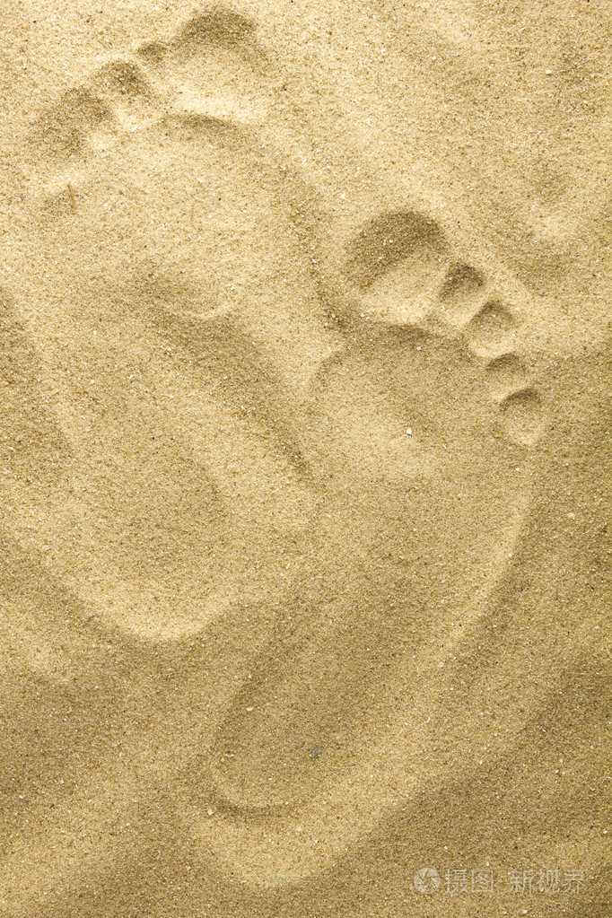 在海滩上的沙子里的两个脚印