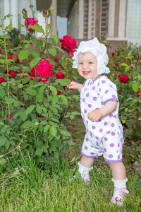微笑与花玫瑰公园里的漂亮的小儿童女孩