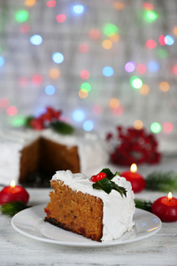 切片蛋糕覆盖在桌子上，在明亮的背景上的圣诞装饰奶油