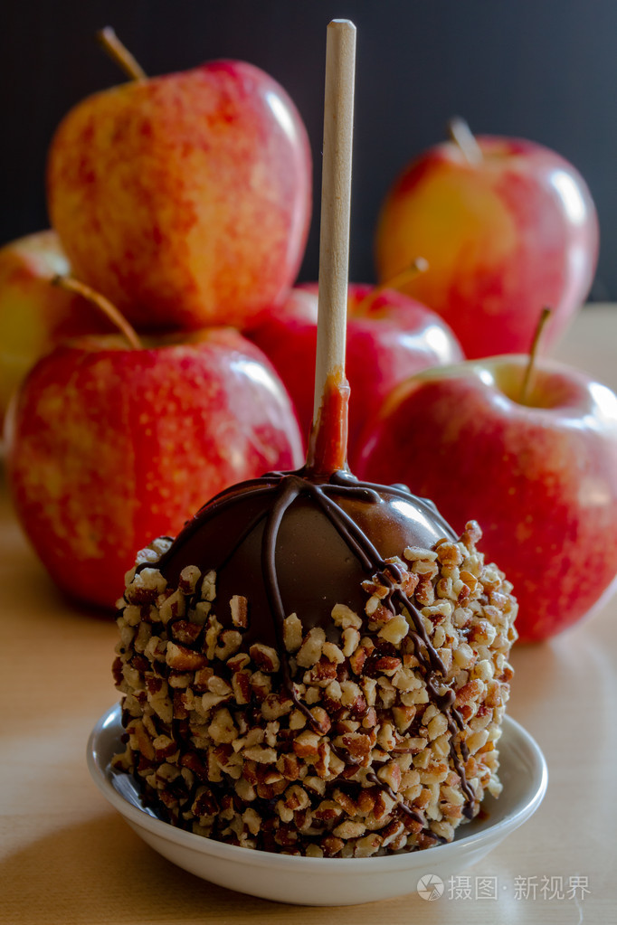 手蘸与坚果和巧克力焦糖苹果
