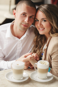 Happy couple drinking coffee in an urban caf.