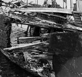 碎片腐烂, 废弃的船在岸上, 颓废和退化的象征, 单色图像