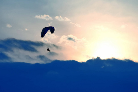滑翔伞在天空的机翼上飞向夕阳