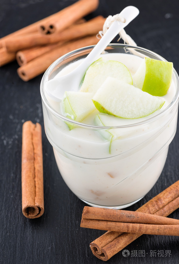 美味酸奶在与苹果和肉桂的玻璃