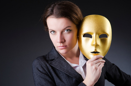 戴着面具的虚伪概念中的女人照片