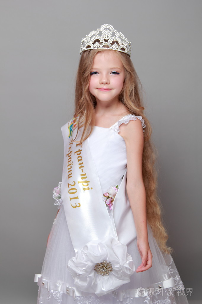 戴着一顶王冠,用一条丝带和言语的白色连衣裙的小女孩"的乌克兰的盛大