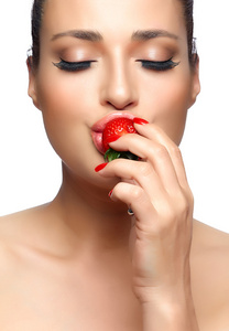 美丽的年轻女子吃草莓