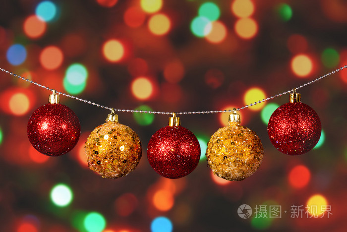 离焦模糊背景上的金色和红色圣诞球照片-正版商用图片0biy9f-摄图新视