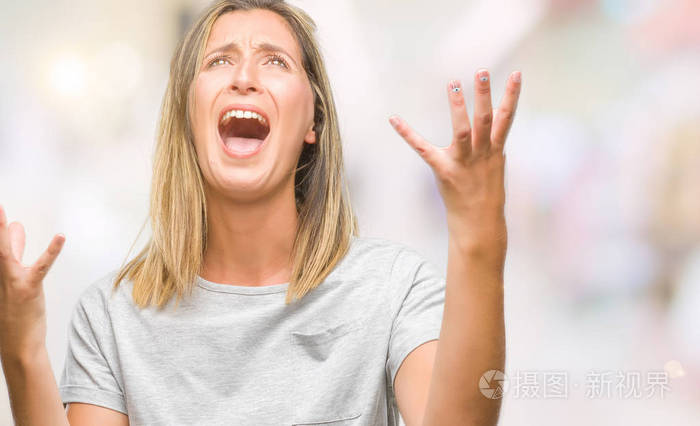 年轻美丽的女人在孤立的背景下疯狂和疯狂的呼喊和激烈的表达和手臂
