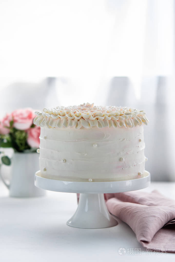 浪漫香草奶油生日蛋糕装饰与珍珠在一个中立的背景。自然光。垂直。复制空间