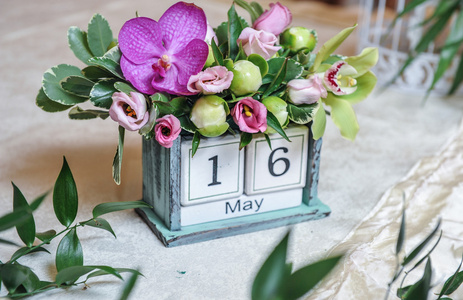 老式的桌面日历用彩色花朵装饰。婚礼日期装饰