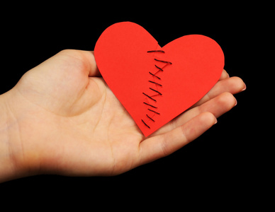 女手里捧着破碎的心缝从两块白色上孤立有吸引力的性感男人的衬衫袖扣