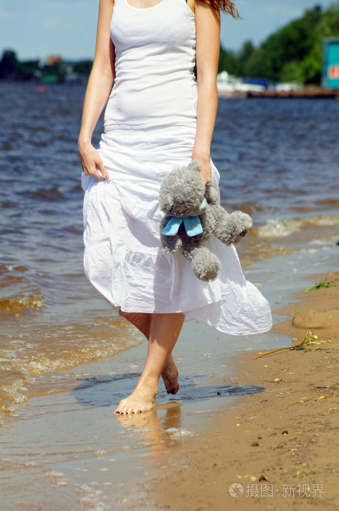 赤脚走在沙滩上的女孩