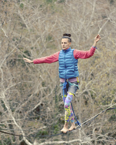 Highliner 在绳子上。Highline 在山的背景上。大自然的极限运动。在吊索上平衡。海拔平衡