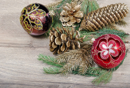 新年背景。新年的球, 圣诞树的树枝和木桌上的金杉木锥体