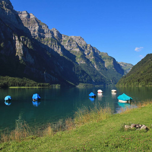 Klontalersee 湖的绿草甸。钓鱼船和山脉 Glarnisch。夏天在瑞士