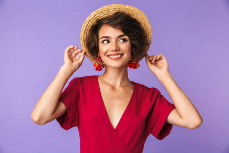 高兴优雅的女人穿着和草帽摆在一边看紫色背景