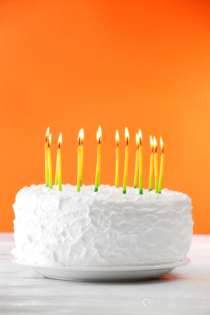 与颜色背景上的蜡烛的生日蛋糕