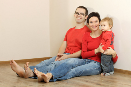 幸福的家庭在牛仔裤和红色衬衫图片