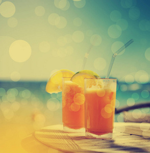 两杯美味橙汁在餐桌上的海滩